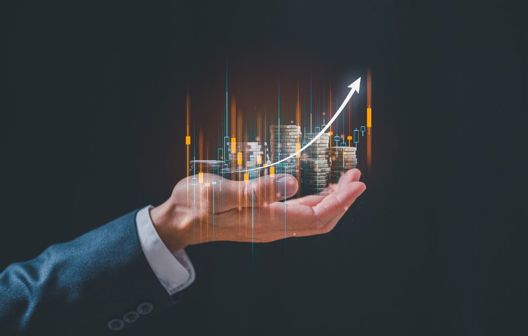 investment and finance concept, businessman holding virtual trading graph and blurred coins on hand