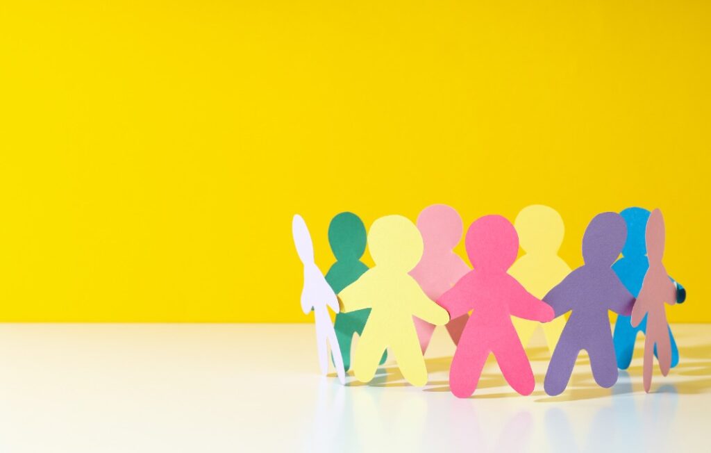 Different colored paper people arranged in a circle