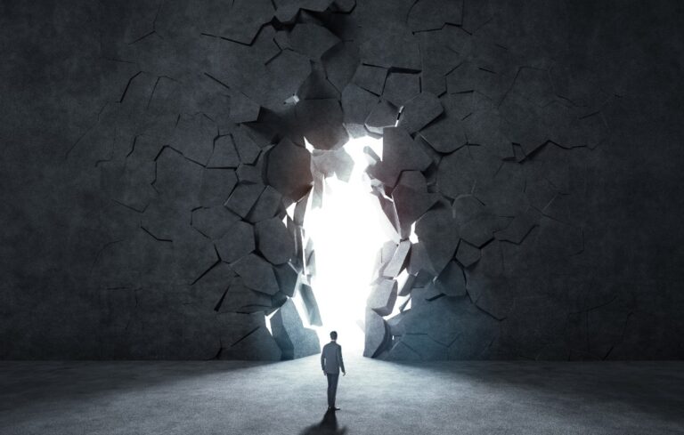 businessman breaking trough a wall