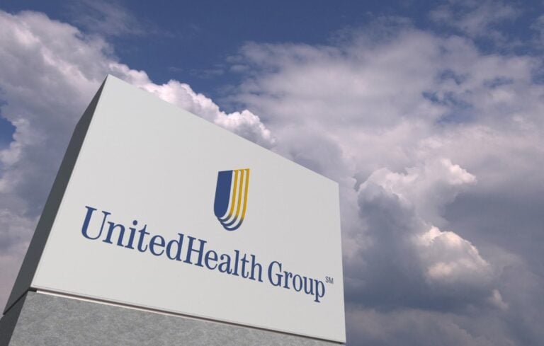Logo of UNITEDHEALTH GROUP on a stand against cloudy sky, editorial 3D rendering