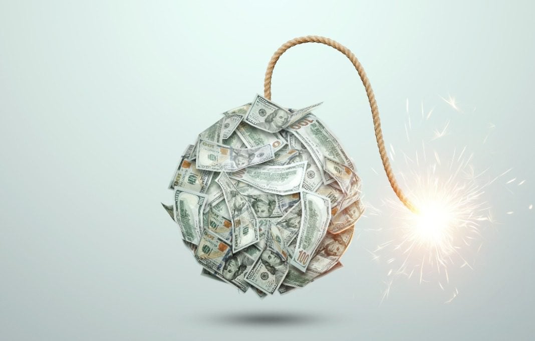 Bomb from money banknotes with a burning wick against white background.