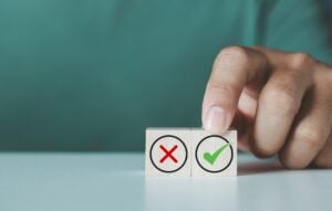 Businessman chooses wooden block with approval mark