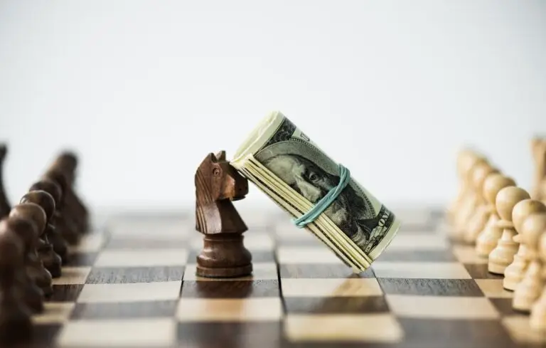 Close up view of chess board with cash and black knight isolated on white