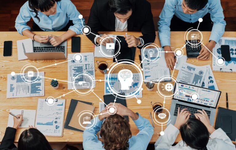 Overhead shot of team working at a table with digital symbols overlayed