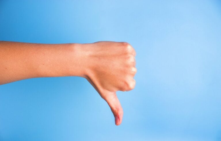 Closeup of woman's hand gesturing thumbs down