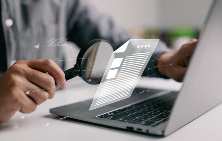Man inspecting paperwork with magnifier.