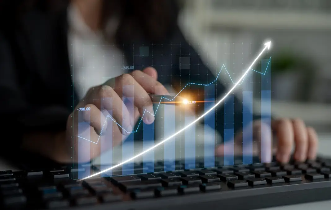 A business professional examines digital financial data on a keyboard