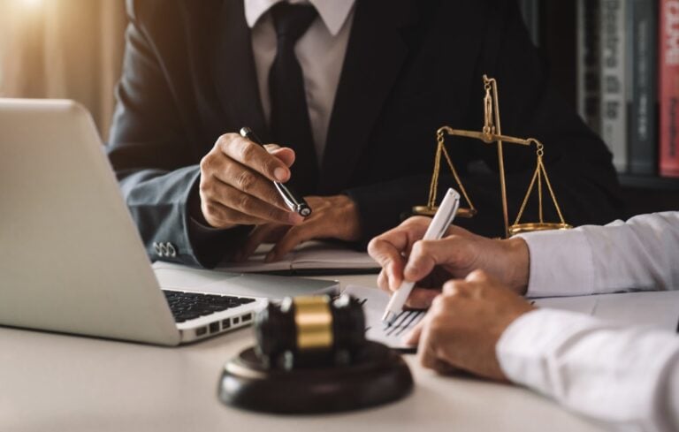 business people and lawyers discussing contract papers sitting at the table.
