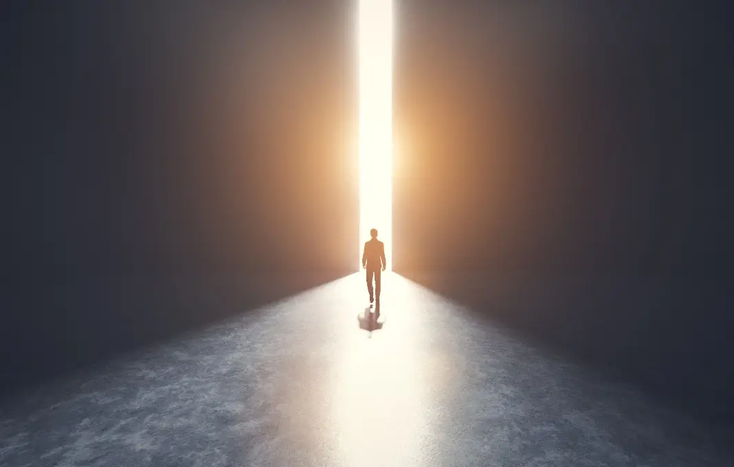 Figure walking through doors into the light