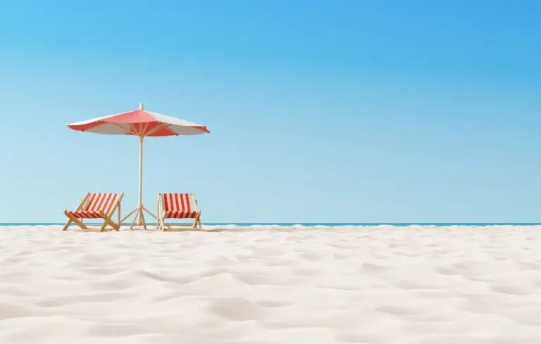 Beach umbrella with chairs on the sand.