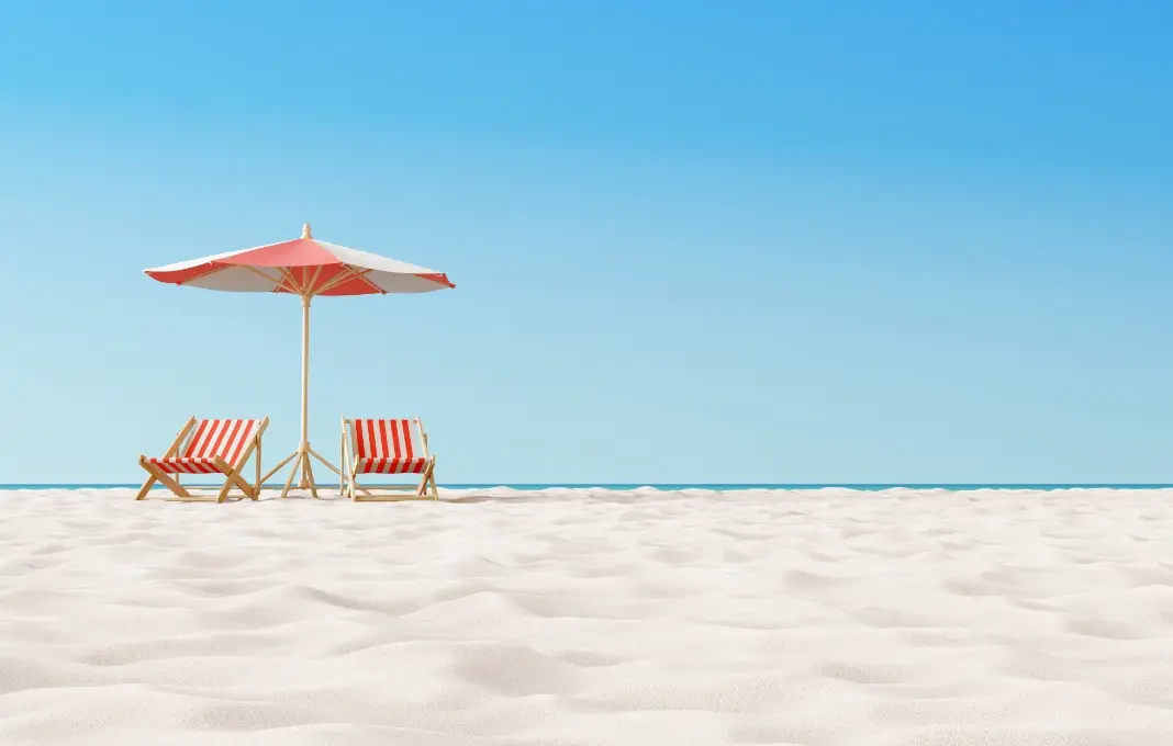 Beach umbrella with chairs on the sand.