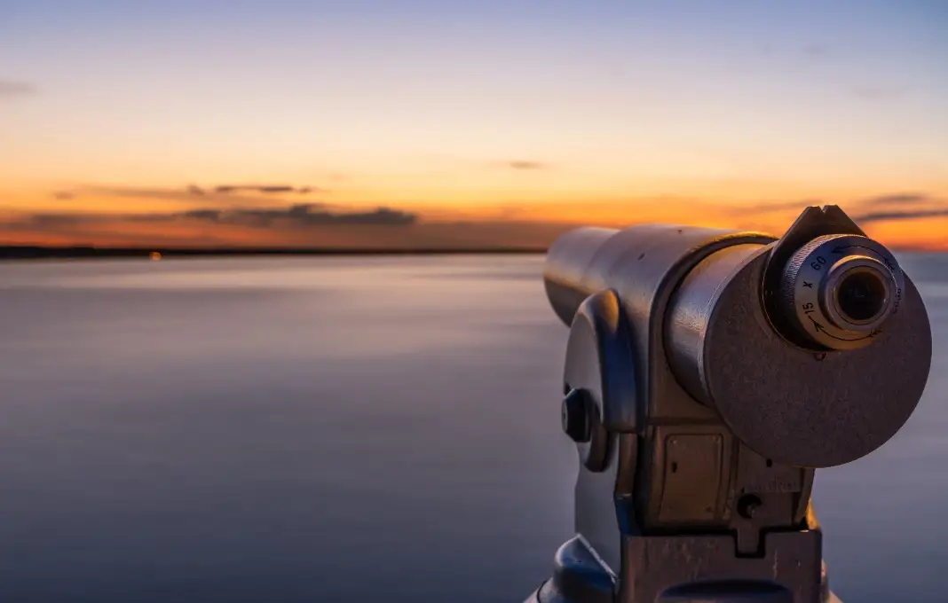 Telescope looking at ocean horizon at sunset