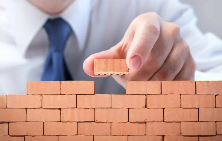 businessman laying miniature bricks