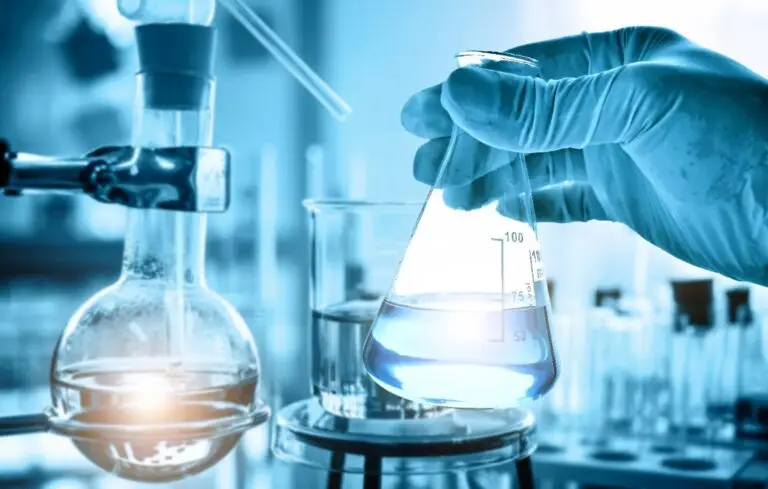 hand of scientist holding flask with lab glassware in chemical laboratory background, science laboratory research and development concept