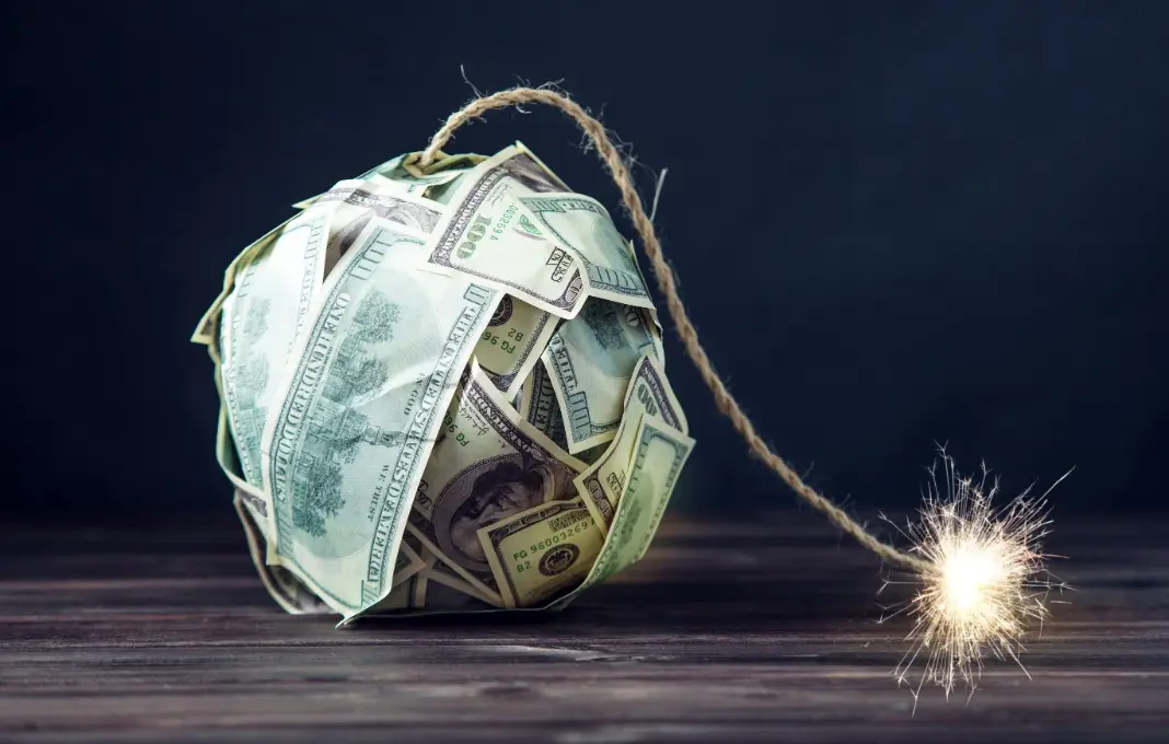 Bomb of money hundred dollar bills with a burning wick.