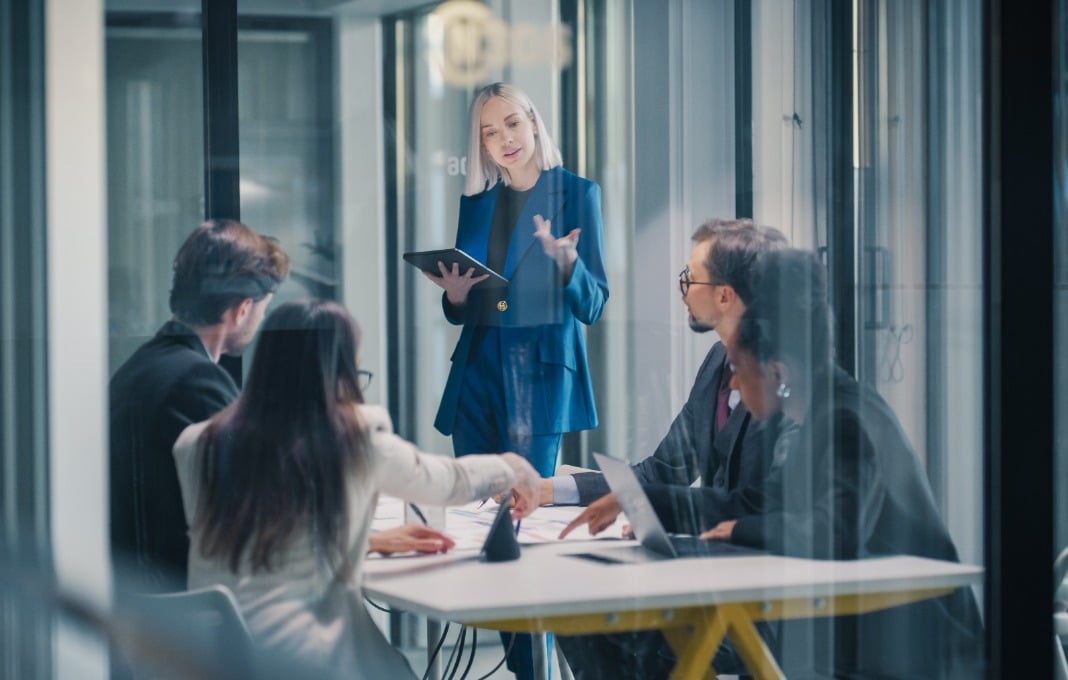 Businesswoman Leads a Strategy Meeting in a Glass Office,